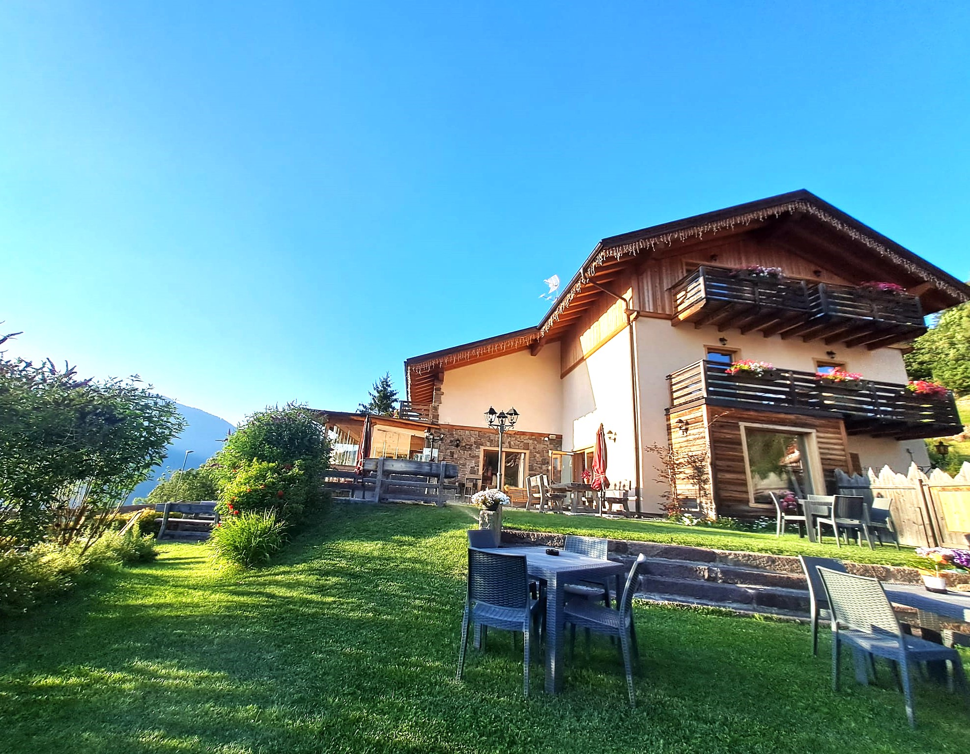 Chalet e tavoli nel giardino estivo